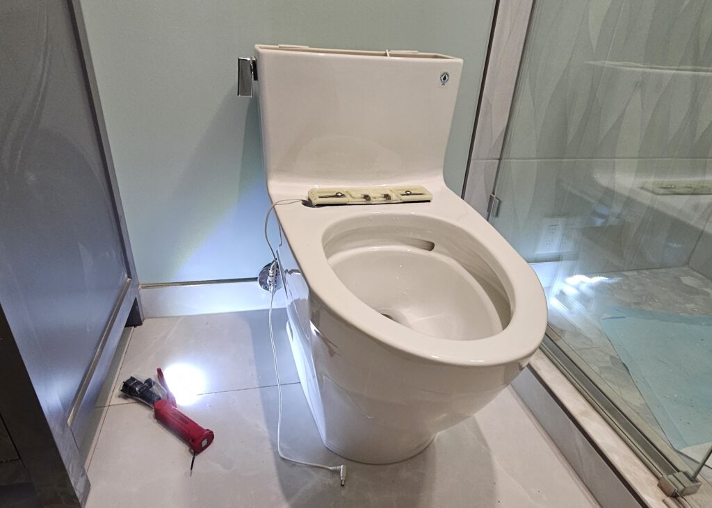 a toilet with a screwdriver and a screwdriver on the floor