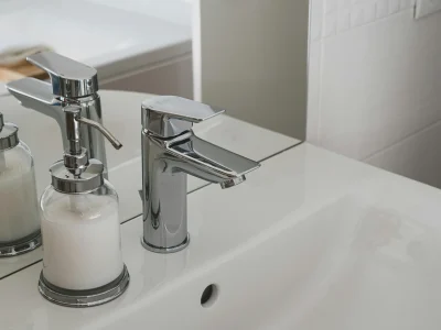 Modern chrome faucet installed on white ceramic basin